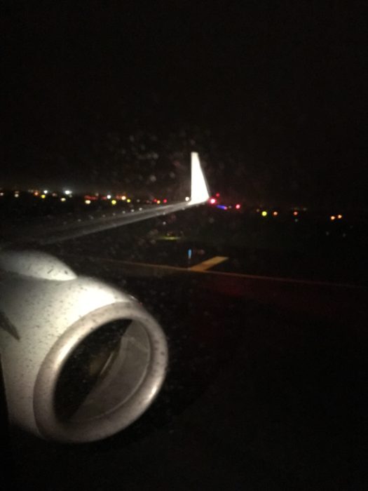 飛機降落在紐約肯尼迪國際機場,窗外落著雨